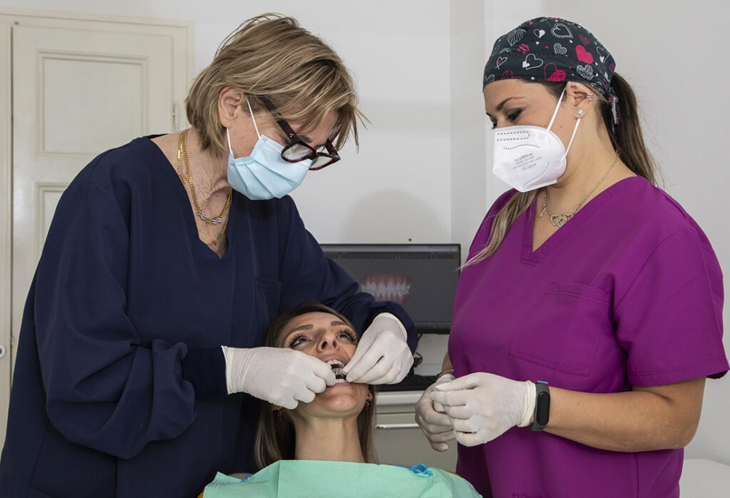 Specialista in ortodonzia dello Studio Ferman durante una visita per l'apparecchio invisibile, con la scansione digitale 3D dei denti visibile sullo schermo.