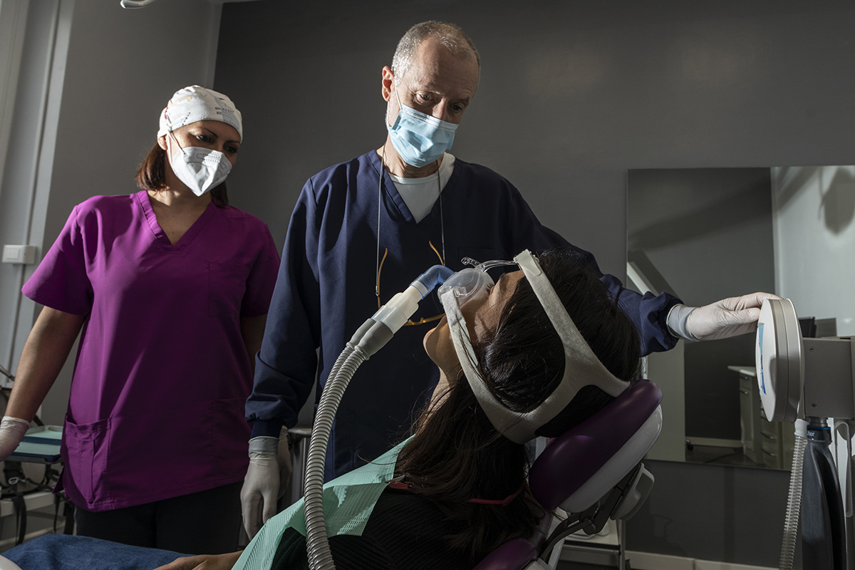 Paziente rilassata con mascherina per la sedazione cosciente durante una cura dentistica